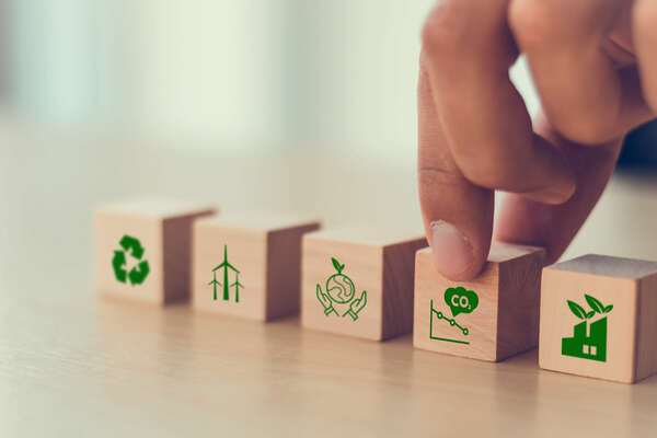 Net zero and carbon neutral concept. Net zero greenhouse gas emissions target. Climate neutral long term strategy. Hand put wooden cubes with decrease carbon emission icon and green icon. Green banner