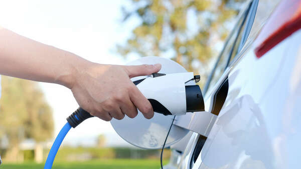 hand charging an EV