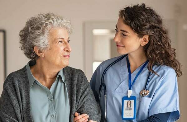 Woman caregiver assists senior woman